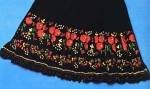 Fekete klott alapon, túlnyomóan piros rózsákkal és „gyöngyvirággal” hímzett kötény (Szécsény vidéke, Nógrád m., 19. sz. eleje) Bp. Néprajzi Múzeum