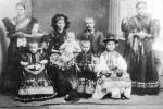 Családi kép az 1910-es évekből. A polgáriasan öltözött családfő mellett felesége csavarítós kendőben, a nagylányon és a fiatalasszonyon még ingváll, de a kislányon már fellökő van